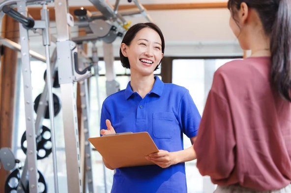 トレーナーがお客様と笑顔で話す様子